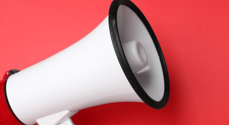 Punavalkoinen megafoni punaista taustaa vasten.